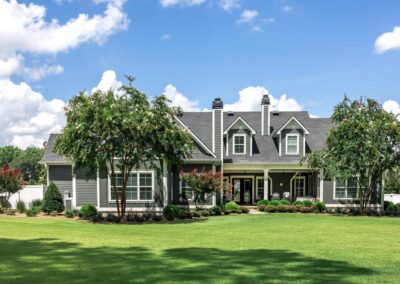 the rear view of a large gray craftsman new construction house