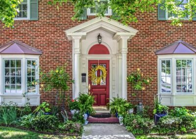 a beautiful two-story brick house with pots of flowers