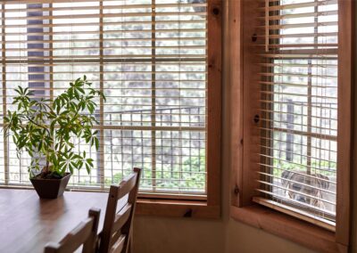 a wooden kitchen table and chairs near a window